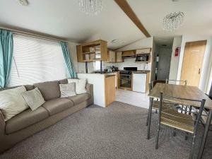 a living room with a couch and a table at Great 8 Berth Caravan With Wifi At Dovercourt Holiday Park In Essex Ref 44003c in Great Oakley
