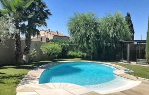 a small swimming pool in a yard with trees at La Villa De Sévigné in Rognonas