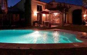 a swimming pool in front of a house at night at La Villa De Sévigné in Rognonas