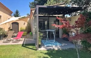 a patio with a table and chairs in a backyard at La Villa De Sévigné in Rognonas