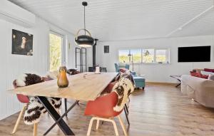 a living room with a wooden table and chairs at 2 Bedroom Stunning Home In Jægerspris in Jægerspris