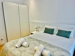 Un dormitorio con una gran cama blanca con almohadas. en Sagues Beach Apartment, en San Sebastián