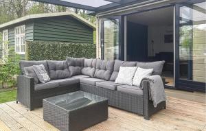 un sofá gris sentado en un patio con una mesa en Amazing Stacaravan In Zeeland, en Zelanda