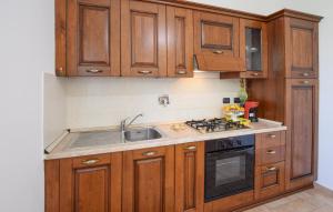 een keuken met houten kasten en een wastafel bij 2 Bedroom Nice Home In Porchiano in Porchiano