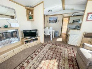 a living room with a flat screen tv and a couch at Ref 40035nd - Superb Caravan With Decking Free Wifi At North Denes Holiday Park in Lowestoft