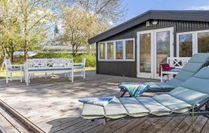 una terraza con sillas azules y una casa en Awesome Home In Jgerspris With Kitchen, en Jægerspris