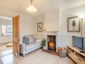 a living room with a couch and a television at Gardeners Cottage in Overstrand
