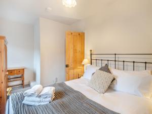 a bedroom with a large bed with towels on it at Gardeners Cottage in Overstrand