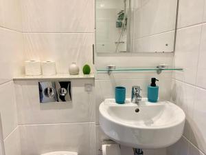 a white bathroom with a sink and a mirror at HNFC Stays - Ocean Central Newcastle Studio w/ Free parking + Gym in Newcastle upon Tyne +9 photos