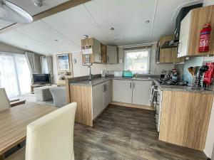 a kitchen with wooden cabinets and a table in a room at Stunning 6 Berth Caravan At Suffolk Sands Holiday Park Ref 45031g in Felixstowe
