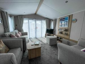 ein Wohnzimmer mit einem Sofa und einem TV in der Unterkunft Stunning 6 Berth Caravan At Suffolk Sands Holiday Park Ref 45031g in Felixstowe