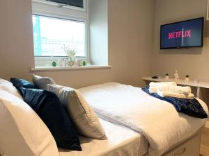 ニューカッスル・アポン・タインにあるHNFC Stays - Ocean Central Newcastle Studio w/ Free parking + Gymの壁にテレビが備わるドミトリールームのベッド1台分です。