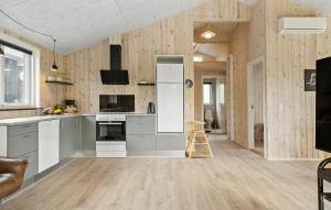 Stunning Home In Vinderup With Kitchen في Vinderup: مطبخ به أجهزة بيضاء وجدران خشبية