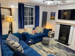 a living room with a blue couch and a fireplace at SNUGGLES in Weymouth