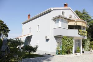 Una casa blanca con plantas a un lado. en Apartments Titonel en Savudrija