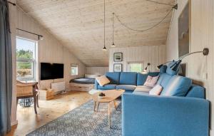 Cozy Home In Silkeborg With Wifi في سيلكبورج: غرفة معيشة مع أريكة زرقاء وطاولة