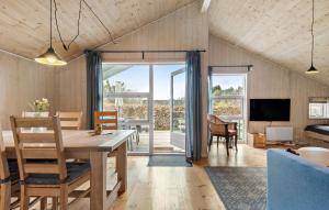 Cozy Home In Silkeborg With Wifi في سيلكبورج: غرفة طعام وغرفة معيشة مع طاولة وكراسي
