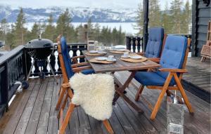 un tavolo e sedie in legno su una terrazza con griglia di Awesome Home In Fyresdal With Kitchen a Fyresdal
