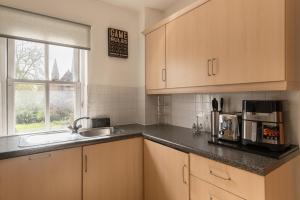 uma cozinha com armários de madeira, um lavatório e uma janela em Superb 1bed flat in Maida Vale em Londres