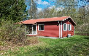 una pequeña casa roja con techo rojo en Stunning Home In Frvang With Outdoor Swimming Pool en Fårvang