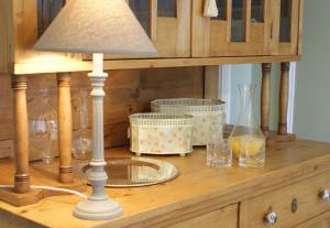 a table with a lamp and glasses on a cabinet at La Gougeonnais in La Richardais
