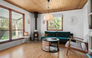 ein Wohnzimmer mit einem grünen Sofa und einem Tisch in der Unterkunft Stunning Home In Frvang With Outdoor Swimming Pool in Fårvang