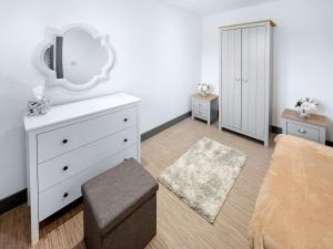 een slaapkamer met een witte dressoir en een spiegel bij Spring Lodge in Southbourne