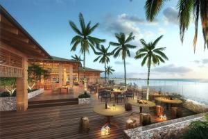 un restaurante en la playa con mesas y palmeras en Salterra, a Luxury Collection Resort & Spa, Turks & Caicos , en Cockburn Harbour