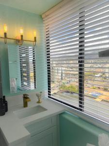 a bathroom with a sink and a window with a view at Hawaiian Monarch 1611 condo in Honolulu