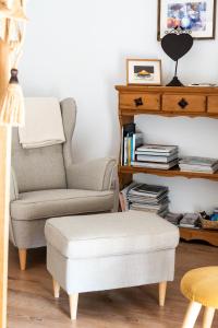 a living room with a chair and a ottoman at La petite madeleine - Chambre d'hôtes & spa in Burgy