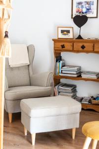 sala de estar con silla y reposapiés en La petite madeleine - Chambre d'hôtes & spa, en Burgy