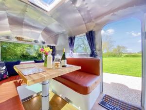 HawthornにあるLanes End Farm Airstreamのテーブルと窓が備わるキャラバンの内側の景色を望めます。