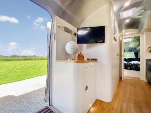 a caravan conversion with a view of a green field at Lanes End Farm Airstream in Hawthorn