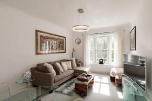 uma sala de estar com um sofá e uma televisão em Superb 1bed flat in Maida Vale em Londres