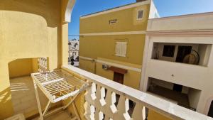 a balcony with a white bench on a building at Hotel Le Pelagie in Lampedusa