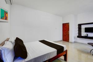 a bedroom with a bed in a room at OYO Kovalam Residency in Chennai