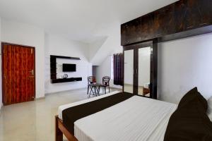 una camera con letto, tavolo e sedie di OYO Kovalam Residency a Chennai