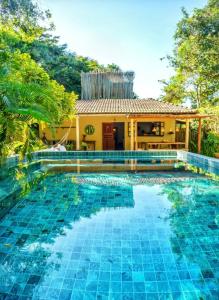 a swimming pool in front of a villa at Pousada Vila Biribiri Trancoso in Trancoso