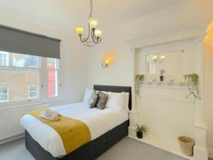 1 dormitorio con cama y lámpara de araña en Luxury Apartment in Paddington, en Londres