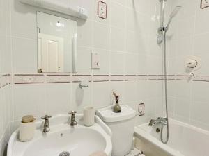 Baño blanco con aseo y lavamanos en Luxury Apartment in Paddington, en Londres