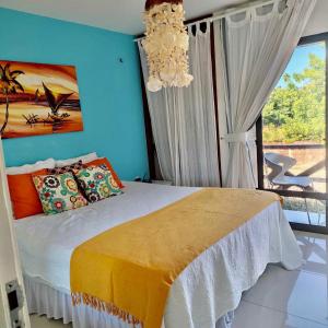 a bedroom with a bed with a chandelier and a window at FRENTE MAR - Cumbuco - Eco Paradise in Cumbuco