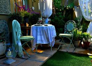 a table and chairs in a garden with plants at SAGE Cottage Bloubergstrand in Cape Town