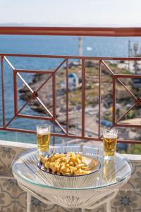 a table with a plate of food and two glasses of beer at Shell-Charm w/Sea View & Parking in Piraeus