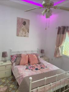 a bedroom with a bed with a ceiling fan at Kujabi Holiday Home in Lamin
