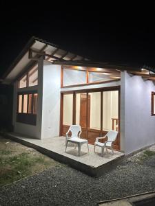 two chairs on a patio in front of a house at Eco Cabañas Montana in Santa Helena