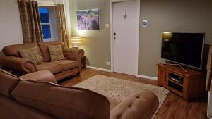 un soggiorno con divano e TV di Underhill Holidays - Underhill Holiday Cottage a Whitby