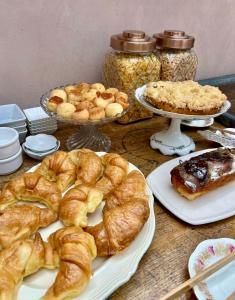 a table topped with plates of croissants and other pastries at Antigua Casona Bed & Breakfast in San Antonio de Areco