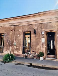 una bicicletta parcheggiata di fronte a un edificio di Antigua Casona Bed & Breakfast a San Antonio de Areco
