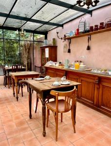 una cocina con mesas y sillas de madera en una habitación en Antigua Casona Bed & Breakfast en San Antonio de Areco