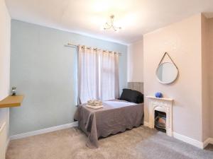 a bedroom with a bed with a mirror and a fireplace at Lovely large 2-Bed House with 2 Reception Rooms in Atherstone